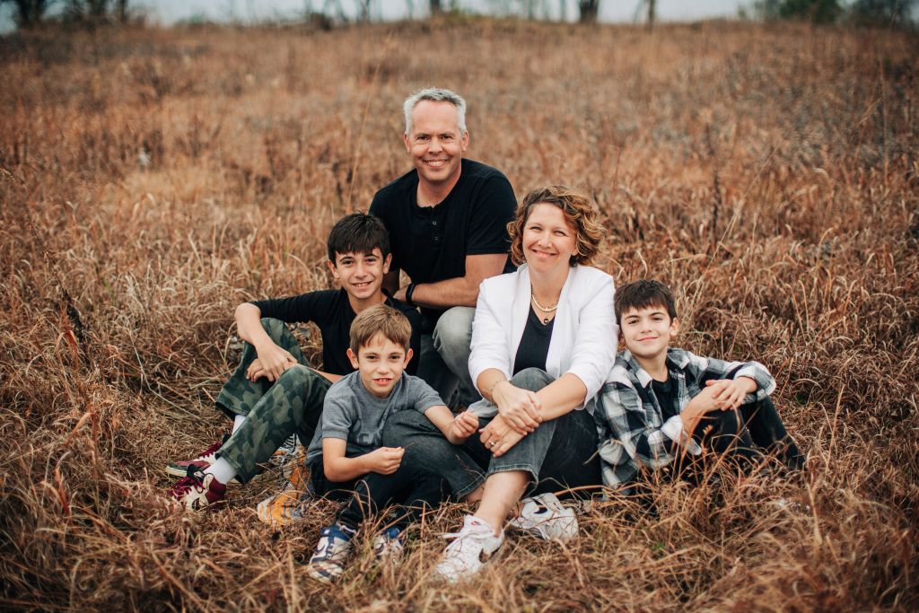 Bert and Kryna in a dry grass field with their three boys in Harrison